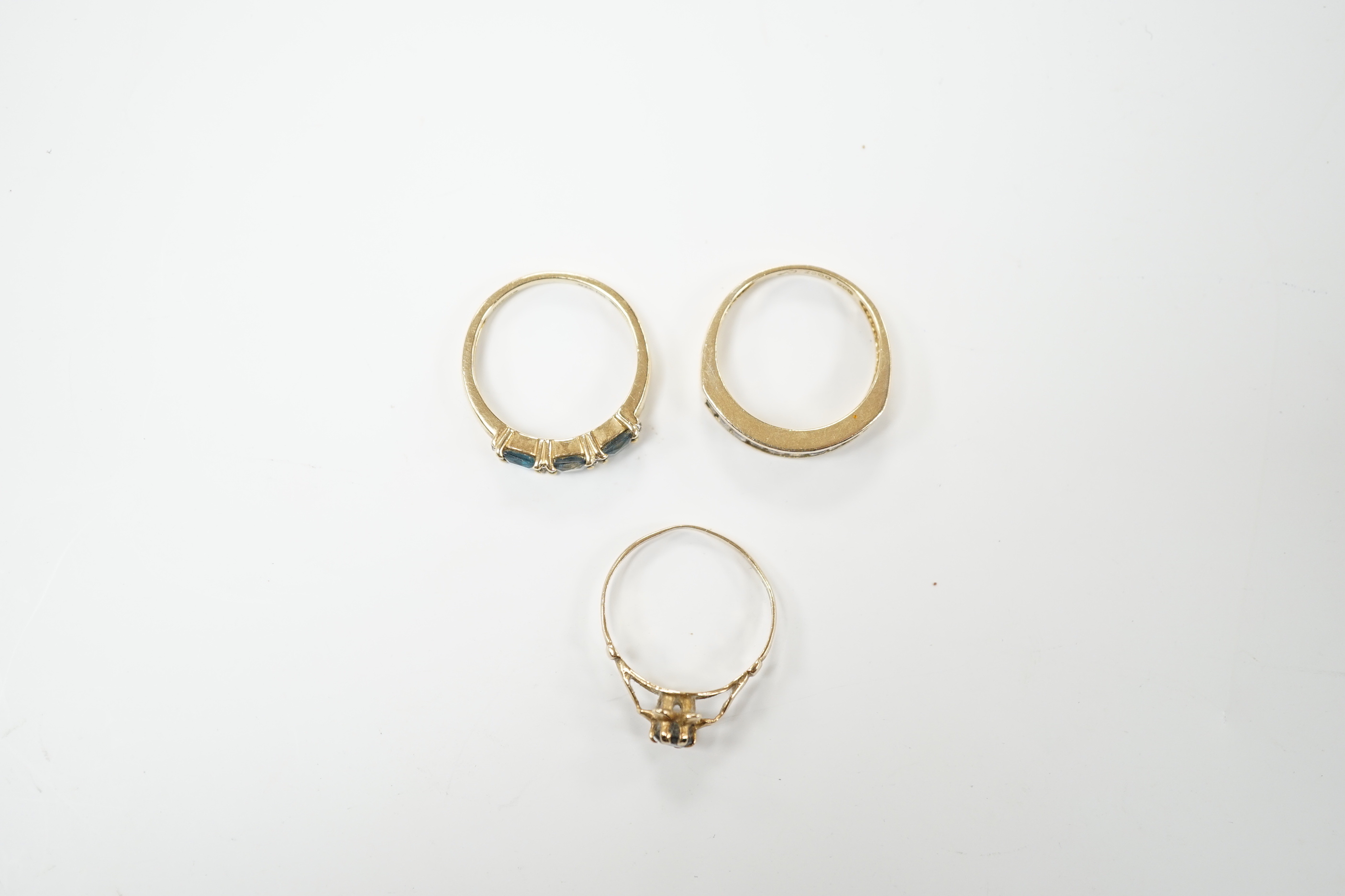 Two 9ct gold dress rings, one set with sapphire and diamonds, the other a single sapphire, and a diamond chip set ring, stamped 925, size M